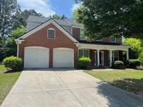 Charming two-story brick home with a well-maintained lawn and an attached two-car garage at 663 Prada Ct, Lawrenceville, GA 30043
