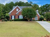 Charming red brick home with a well-manicured lawn and mature trees at 1093 Spruce Creek Ln, Lawrenceville, GA 30045