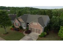 Beautiful, brick home features a well-manicured lawn, professional landscaping, and two car garage at 6614 Covered Bridge Way, Braselton, GA 30548