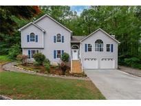 Charming home with manicured lawn, beautiful landscaping, and a two-car garage at 204 Queensbury Ct, Acworth, GA 30102