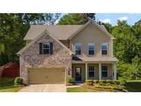 Charming two-story home featuring a mix of brick and siding, complemented by manicured landscaping at 4830 Frontier Dr, Cumming, GA 30028