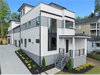 Modern three-story home featuring a white and gray exterior with manicured landscaping at 90 Cleveland Unit A Se St, Atlanta, GA 30316