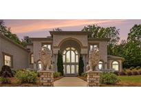 Stunning brick home with prominent lion statues, grand archway, and manicured landscaping at 2425 Wild Oak Ct, Stockbridge, GA 30281