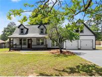 Charming two-story home with a welcoming front porch and a convenient two-car garage at 2979 Overwood Sw Ln, Snellville, GA 30078