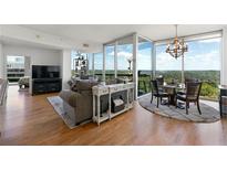 Bright living room features hardwood floors, floor to ceiling windows, neutral colors, and a decorative fireplace at 3300 Windy Ridge Se Pkwy # 1401, Atlanta, GA 30339