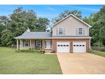 Charming two-story home with a well-manicured lawn, two-car garage, and covered front porch at 4326 Megan Manor Sw Dr, Powder Springs, GA 30127