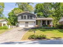 Charming two-story home with a well-manicured lawn and welcoming front entrance with a bright yellow door at 2991 Windfield Cir, Tucker, GA 30084