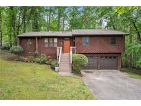 Charming two-story home with an orange door, lush landscaping, and a two car garage at 3679 Regent Nw Dr, Kennesaw, GA 30144