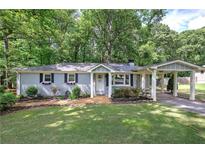Charming single-story home with a welcoming front yard and a covered carport at 3710 Lavilla Dr, Powder Springs, GA 30127