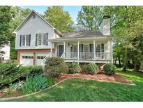 Charming two-story home featuring a welcoming front porch, manicured lawn, and an attached two-car garage at 4739 Bradford Ln, Powder Springs, GA 30127