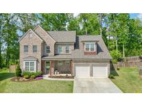 Beautiful two-story brick home with manicured lawn and attached two-car garage at 242 Fieldbrook Xing, Canton, GA 30115