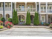 Charming townhome with brick accents, small evergreens, and vibrant red roses near the entryway at 963 Forrest St, Roswell, GA 30075