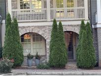 Charming brick townhome entrance with arched doorways and decorative landscaping at 963 Forrest St, Roswell, GA 30075