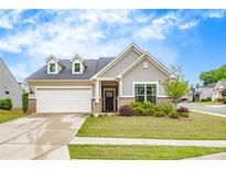 Charming home featuring a two-car garage, stone accents, dormers, and a well-manicured lawn at 463 Marston Pass, Acworth, GA 30102