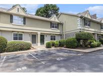 Exterior shot of a two-story townhome featuring neatly trimmed bushes and convenient parking spaces at 6900 Roswell Rd # F6, Atlanta, GA 30328