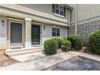 Inviting townhome entrance with stone accents, lush shrubs, and dual front doors at 6900 Roswell Rd # F6, Atlanta, GA 30328