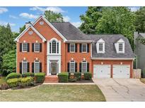 Charming brick two-story home with an attached two-car garage and lush front yard landscaping at 5344 Saint Martins Se Ct, Mableton, GA 30126