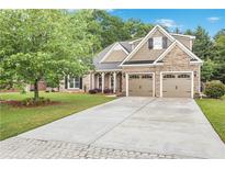 Charming home featuring a well-manicured lawn, brick and stone accents, and a spacious two-car garage at 1593 Fredricksberg Dr, Loganville, GA 30052