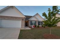 Charming brick home featuring a manicured lawn, two-car garage, and eye-catching architectural details at 710 Park Place Trl, Social Circle, GA 30025