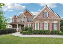 Stunning two-story brick home with manicured lawn and stone accents, exuding curb appeal at 1888 Sever Creek Cir, Lawrenceville, GA 30043