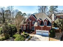Charming two-story brick home featuring a well-manicured front yard and a two-car garage at 389 Mill Creek Ne Bnd, Atlanta, GA 30307