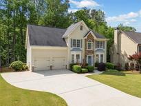 Inviting two-story home with a manicured lawn, stone accents, and a two-car garage at 1126 Gate Post Ct, Powder Springs, GA 30127