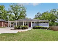 Charming one-story home with a landscaped front yard, carport, and inviting purple front door at 1281 Snapfinger Rd, Decatur, GA 30032