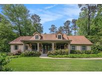 Charming home with stone accents, dormer windows, a lush lawn, and mature landscaping at 351 Old Orchard Ct, Marietta, GA 30068