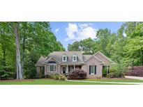 Charming brick home with lush landscaping, mature trees, and a well-manicured lawn at 3445 Strawberry Ln, Cumming, GA 30041