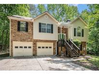 Charming split-level home with stone accents, two-car garage, and inviting front entrance surrounded by mature trees at 300 Alcovy Way, Covington, GA 30014