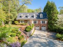 Charming brick home featuring a manicured lawn, beautiful landscaping and a private two-car garage at 4584 E Conway Nw Dr, Atlanta, GA 30327