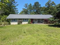 Charming single-story home with a well-maintained yard and a serene, tree-lined backdrop at 2291 Piney Grove Rd, Loganville, GA 30052