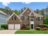 Charming two-story brick home featuring manicured landscaping, double garage and a welcoming entrance at 4114 Suwanee Trail Dr, Buford, GA 30518