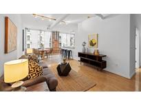 Bright living room with hardwood floors, modern decor, and exposed brick accents offers a stylish living space at 800 Peachtree Ne St # 8509, Atlanta, GA 30308