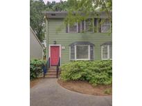 Charming two-story home with a bright pink door and well-maintained landscaping at 6 Holly Downs Nw Ct, Atlanta, GA 30318