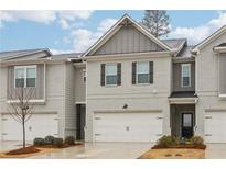 Charming townhome featuring a two-car garage, neutral brick, and well-maintained landscaping at 5575 Rock Place Ct, Norcross, GA 30093