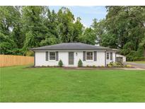 Charming single-story home with a lush green lawn and freshly painted white brick exterior at 2260 Old Spring Se Rd, Smyrna, GA 30080