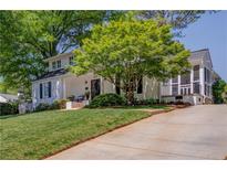 Charming white home featuring a lush green lawn and a mature shade tree at 26 Kensington Rd, Avondale Estates, GA 30002