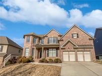 Beautiful two-story brick home with a two-car garage, manicured landscaping, and a welcoming front porch at 4449 Sierra Creek Dr, Hoschton, GA 30548