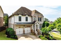 Charming two-story home featuring a brick and white siding facade, two-car garage and well-manicured landscaping at 11760 Stratham Dr, Alpharetta, GA 30009