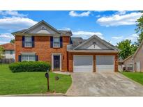 Charming two-story brick home with a well-manicured lawn and attached two car garage at 4000 Crossings Way, Stone Mountain, GA 30083