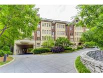 Elegant condo building with lush landscaping, a circular drive and covered parking area at 1717 N Decatur Ne Rd # 214, Atlanta, GA 30307