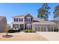 Charming two-story home with a stone facade, three-car garage, and well-manicured lawn at 496 Spring View Dr, Woodstock, GA 30188