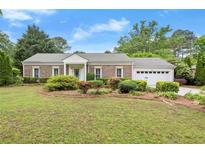 Charming brick ranch-style home with a well-manicured lawn, mature trees, and a two-car garage at 1000 Grimes Bridge Rd, Roswell, GA 30075