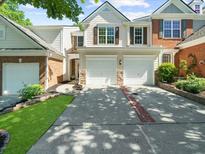 Inviting townhome with a well-manicured lawn and a two-car garage at 220 Finchley Dr, Roswell, GA 30076