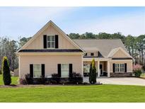 Charming single-Gathering home featuring manicured lawn, inviting curb appeal, and symmetrical window placement at 2767 Camp Mitchell Rd, Loganville, GA 30052