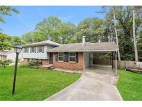 Charming split-level home featuring a carport, brick accents, and a well-manicured lawn at 2757 Shelley Ln, Ellenwood, GA 30294