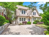 Charming home featuring a stylish brick driveway, manicured shrubs, and a two-car garage at 1028 Amsterdam Ne Ave, Atlanta, GA 30306