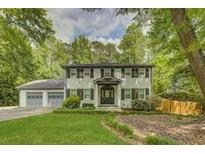 Beautiful two-story house with a well-manicured lawn and a two-car garage, surrounded by mature trees at 1615 Arden Sw Dr, Marietta, GA 30008