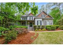 Charming two-story home featuring a covered front porch and well-manicured landscaping at 529 Wintergreen Way, Canton, GA 30115